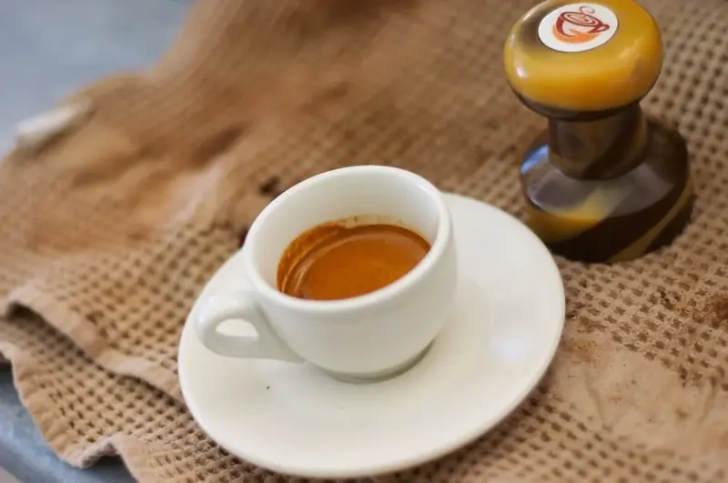 Ristretto servit într-o ceașcă mică, pus pe o farfurie
